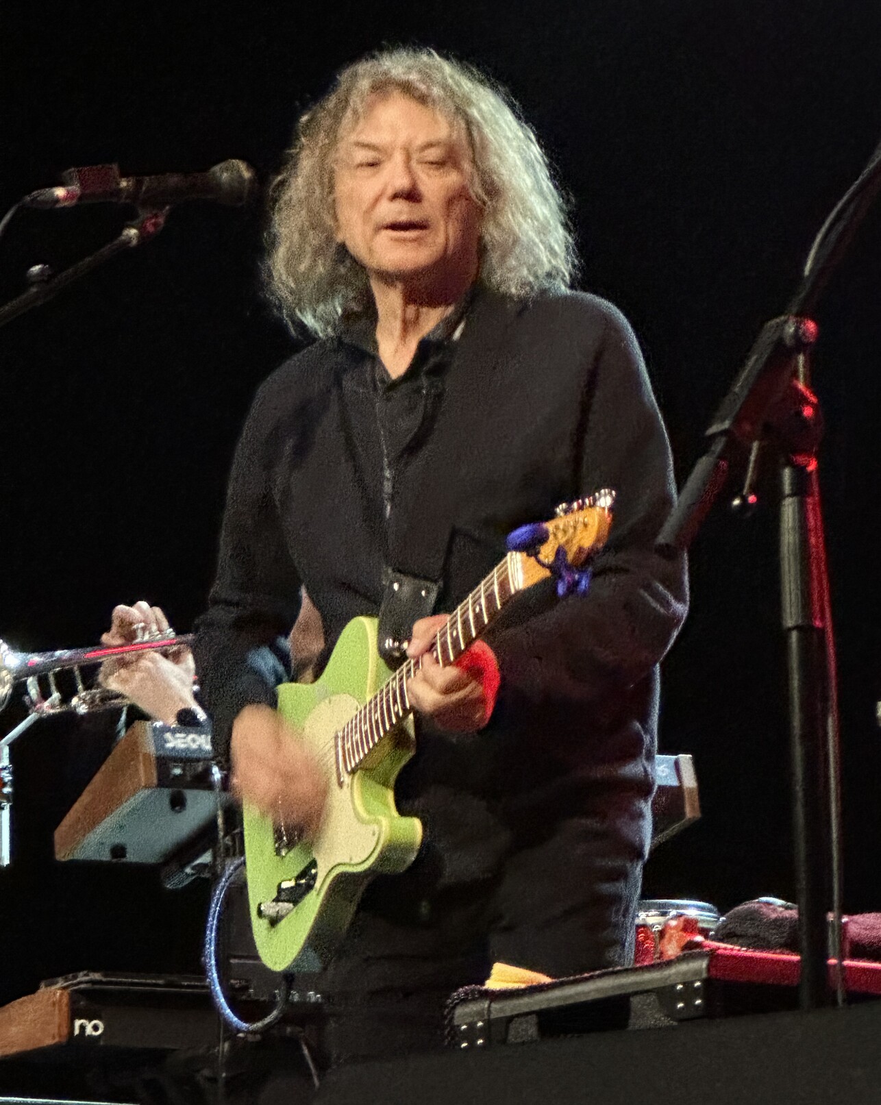 Jerry Harrison on stage playing a green guitar