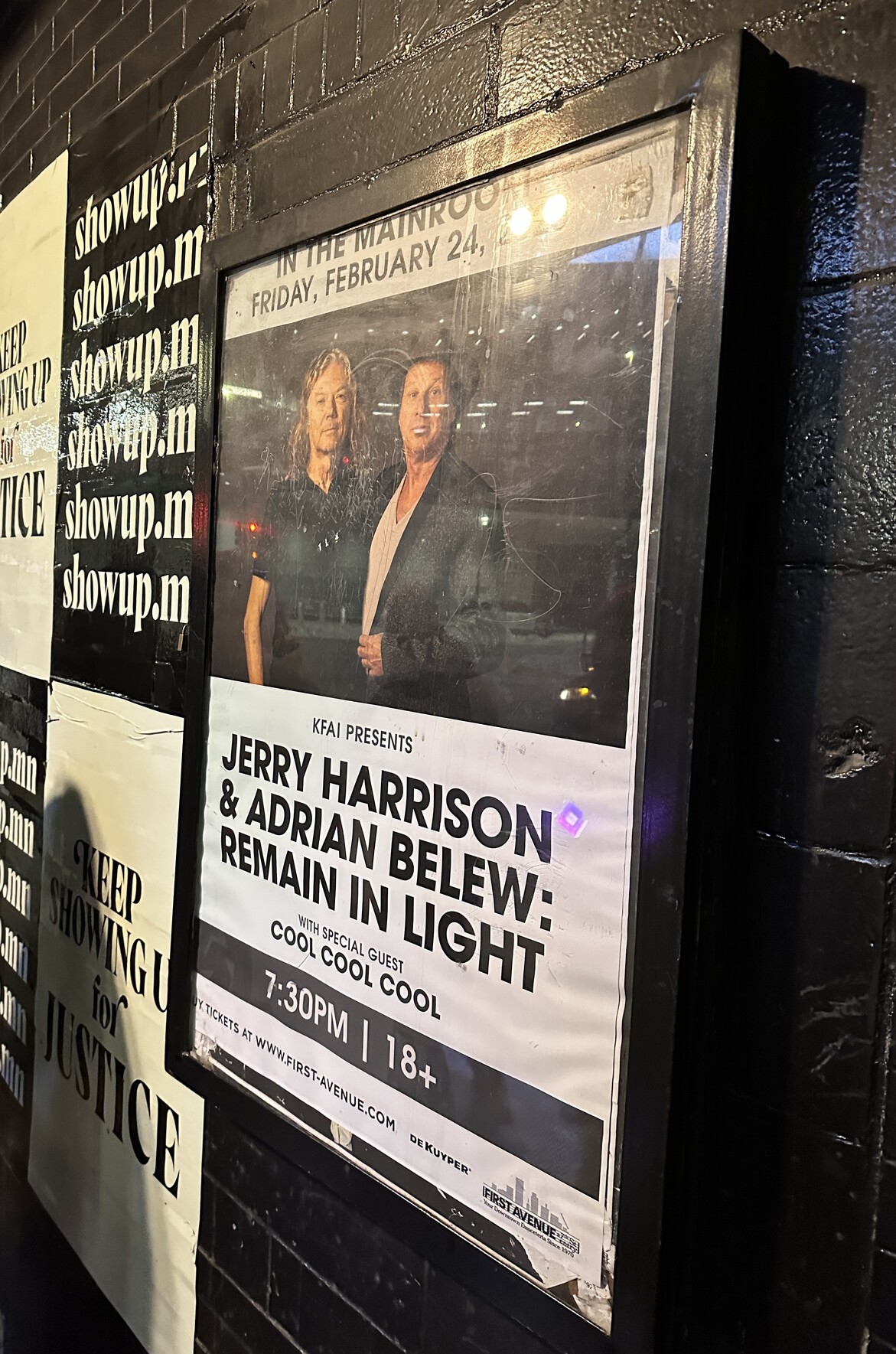 Jerry Harrison & Adrian Belew: Remain in Light poster hanging on the black wall outside the entrance to First Avenue