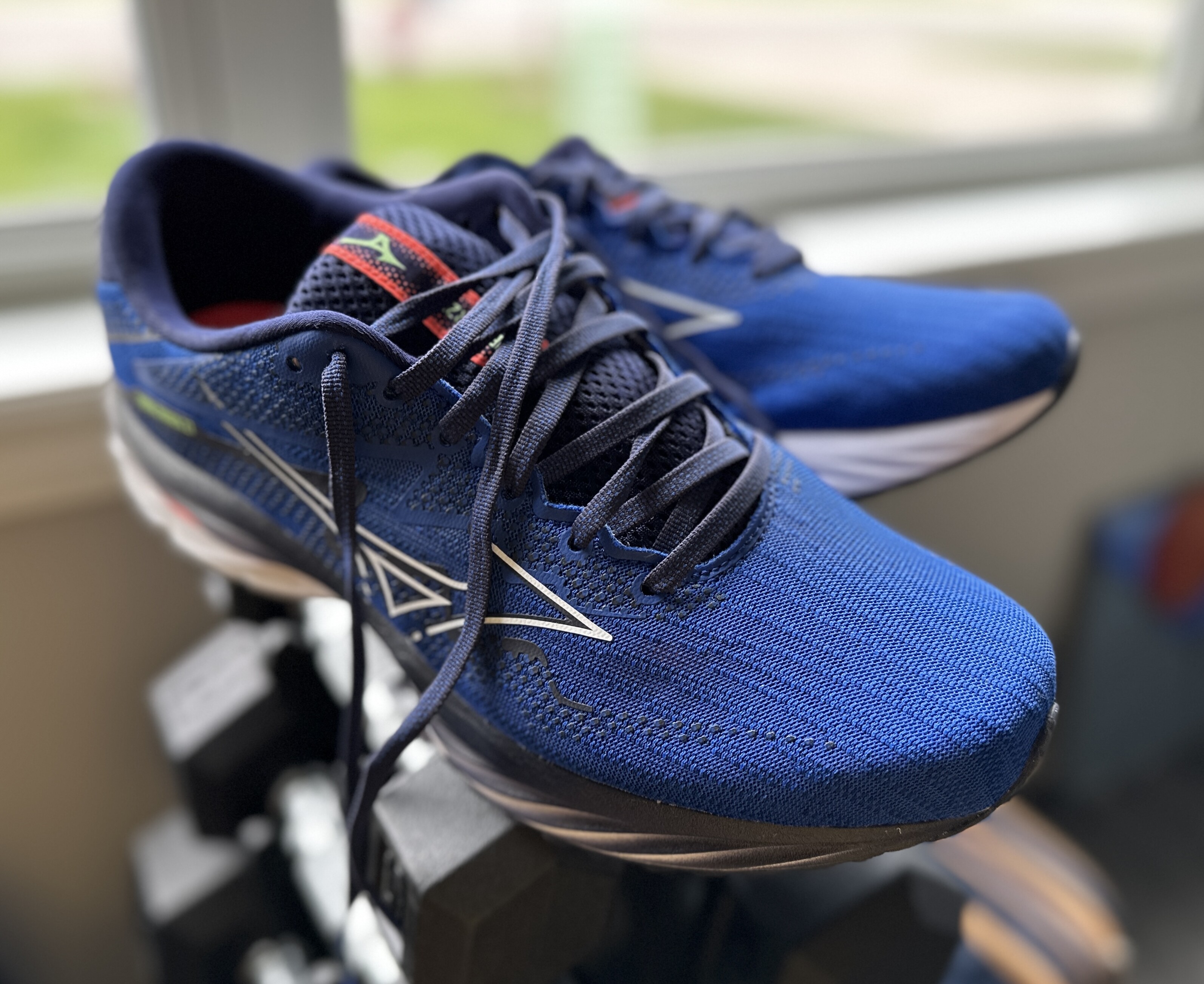 Blue Mizuno Wave Rider 27 running shoes sitting by the window of my office