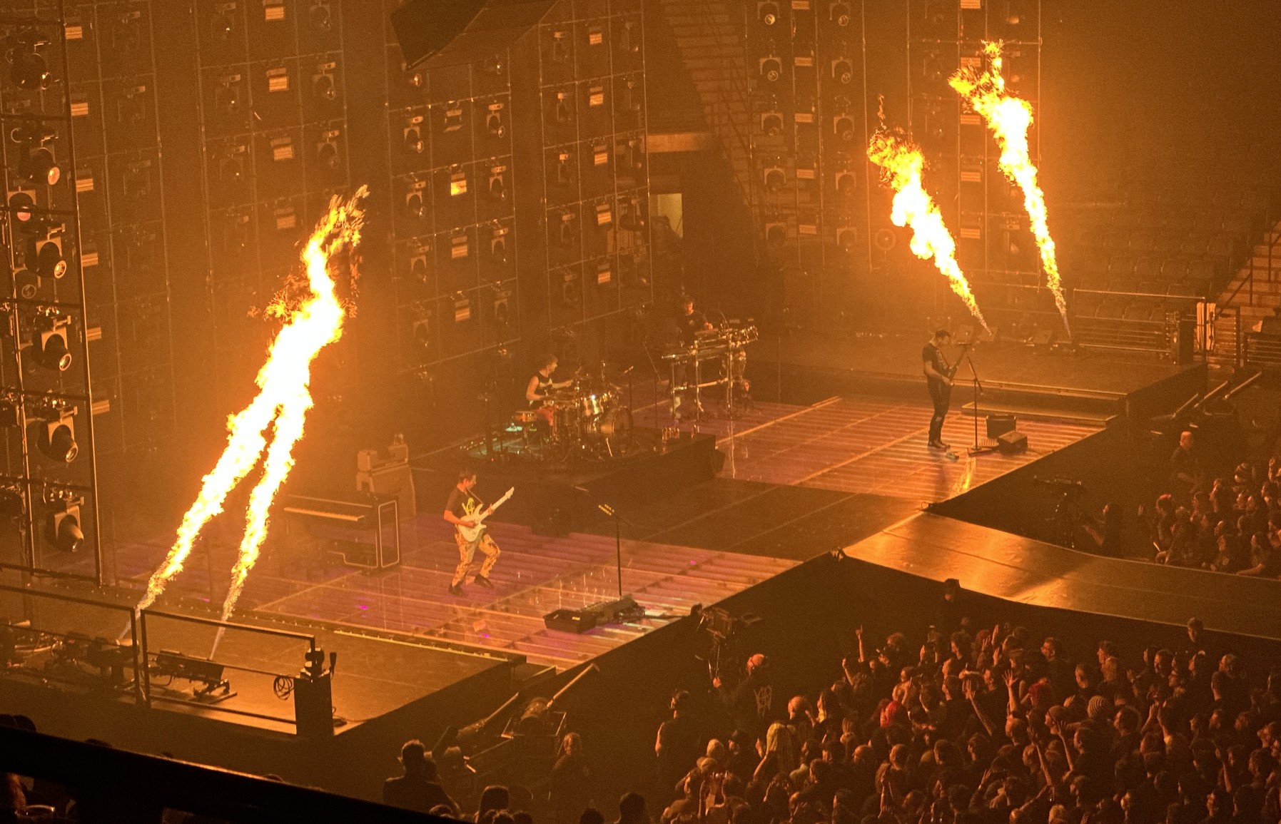Muse playing with four large flames shooting across the stage