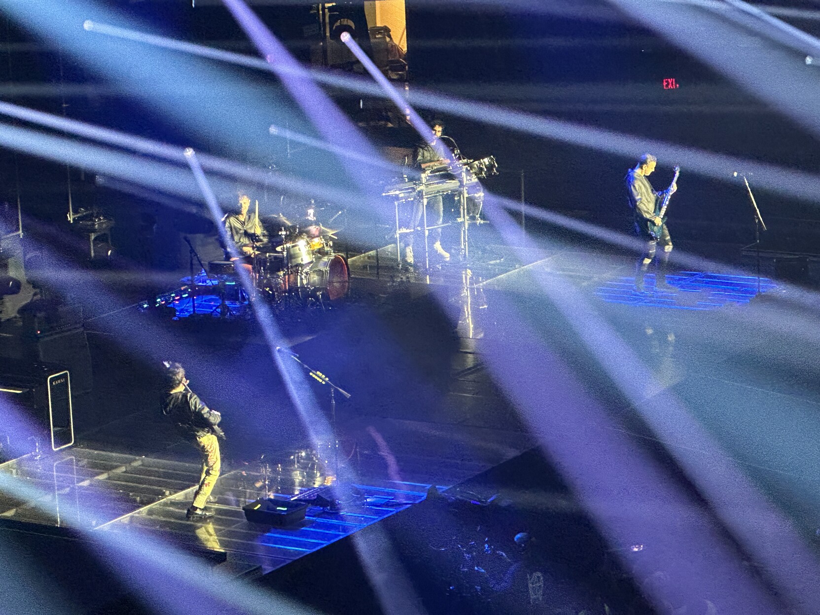 Zoomed in shot of Muse playing with multiple blue spotlights